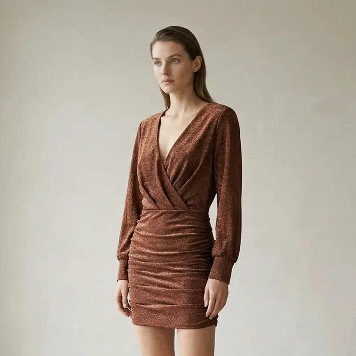 Abito corto drappeggiato in lurex bronzo ZOE con scollo a V incrociato e apertura sulla schiena indossato da modella – Alessandra Gallo