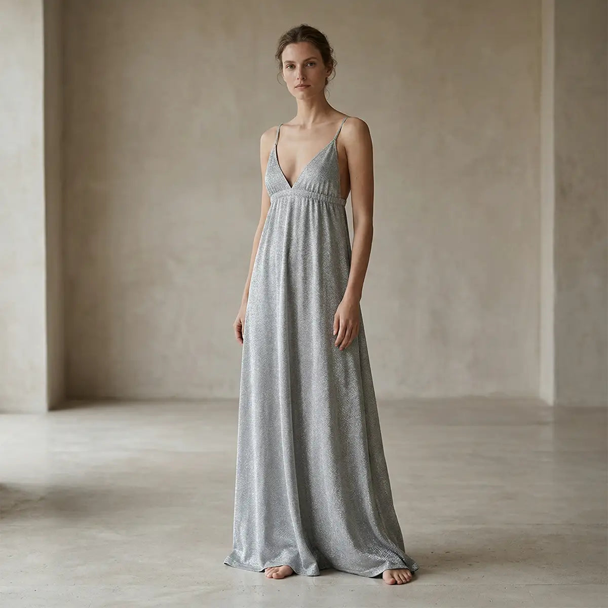 Abito lungo in lurex argento MICOL con scollo a V e schiena scoperta con spalline incrociate indossato da modella – Alessandra Gallo