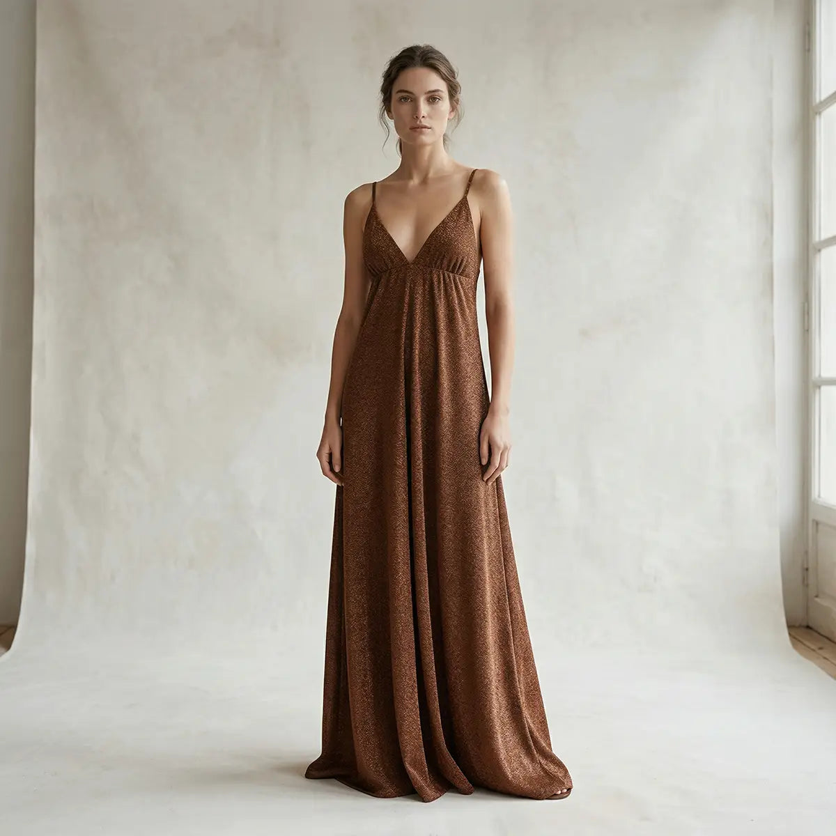 Abito lungo in lurex bronzo MICOL con scollo a V e schiena scoperta con spalline incrociate indossato da modella – Alessandra Gallo