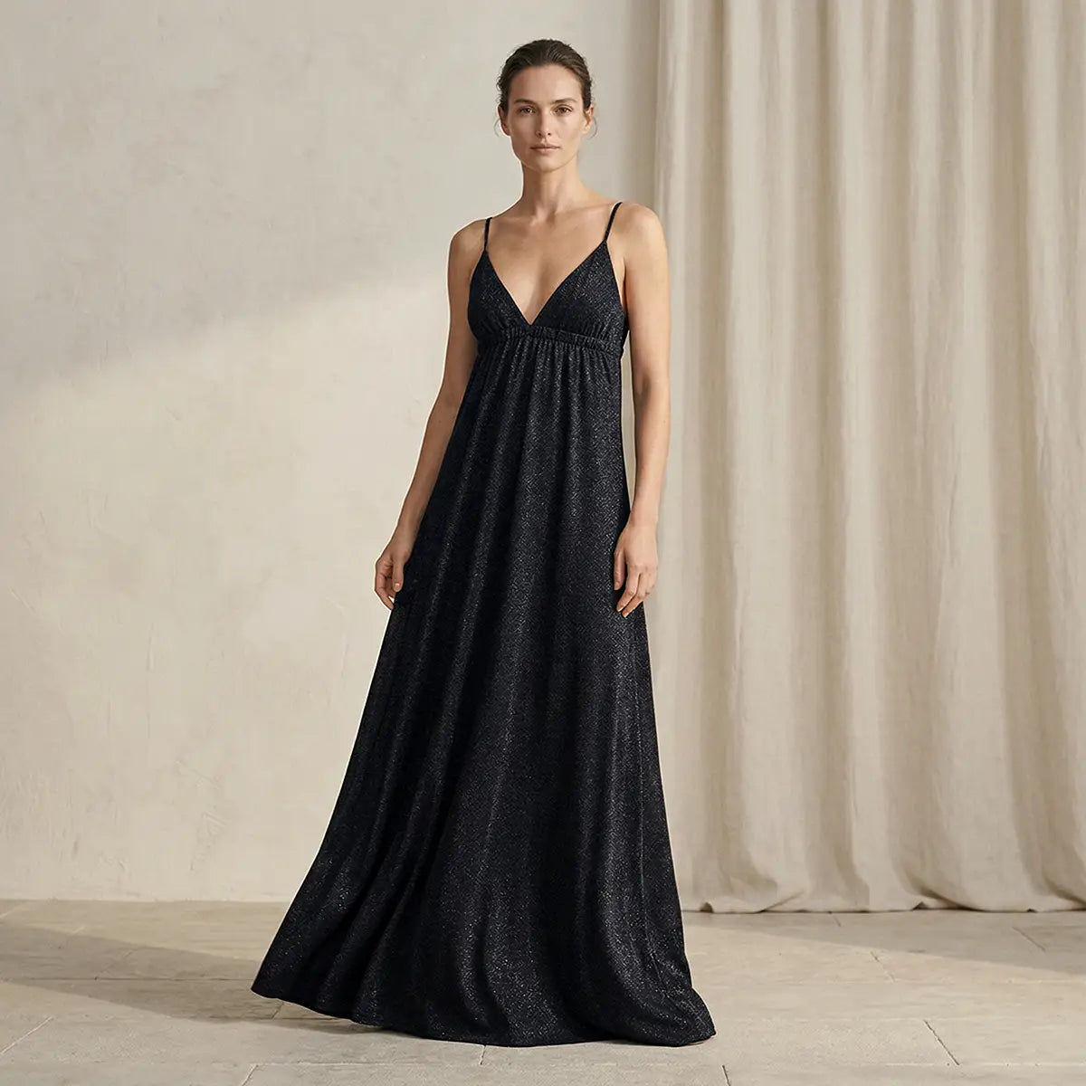 Abito lungo in lurex nero MICOL con scollo a V e schiena scoperta con spalline incrociate indossato da modella – Alessandra Gallo
