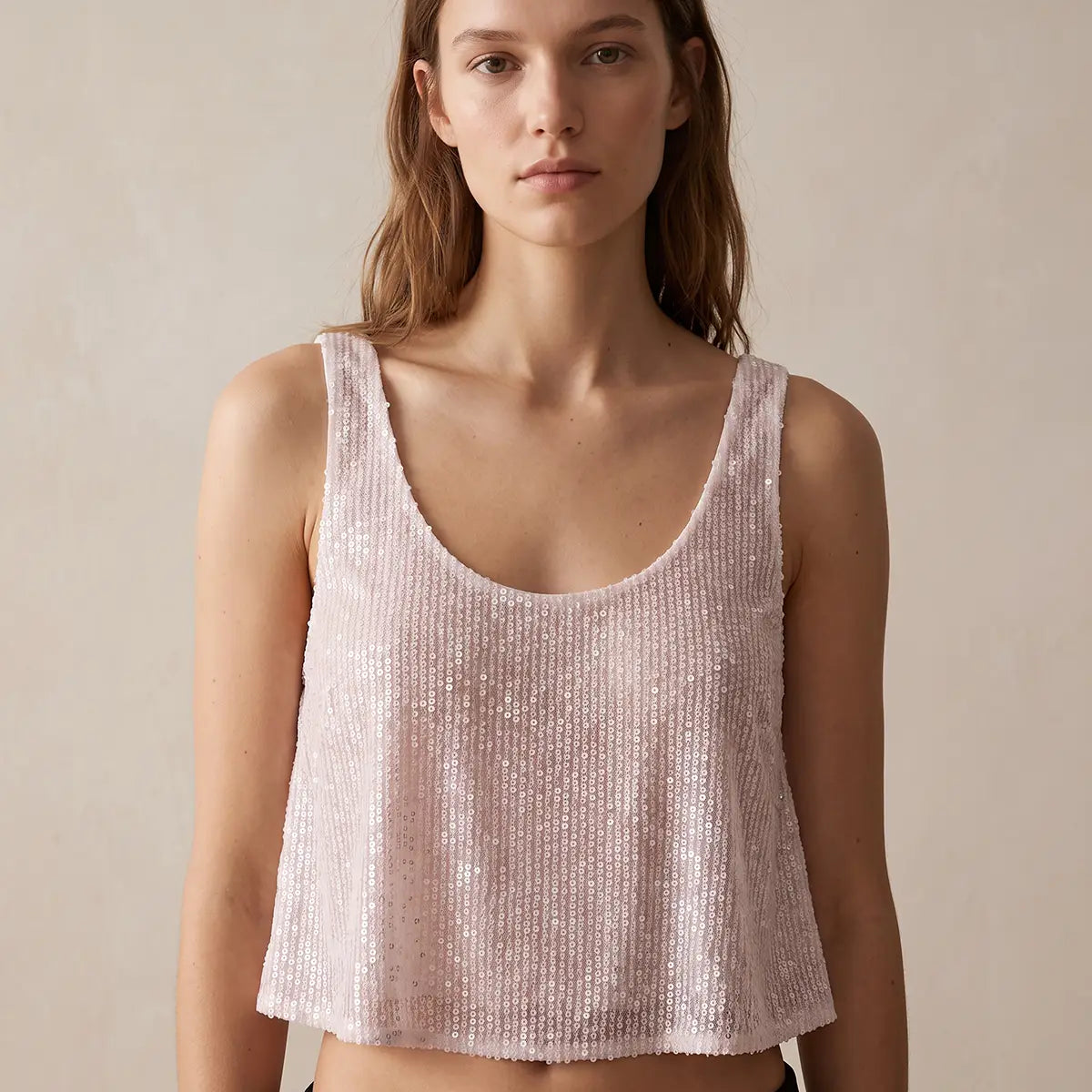 ANDROMEDA, crop top in paillettes bianche con scollo rotondo e spalle larghe, su modella.