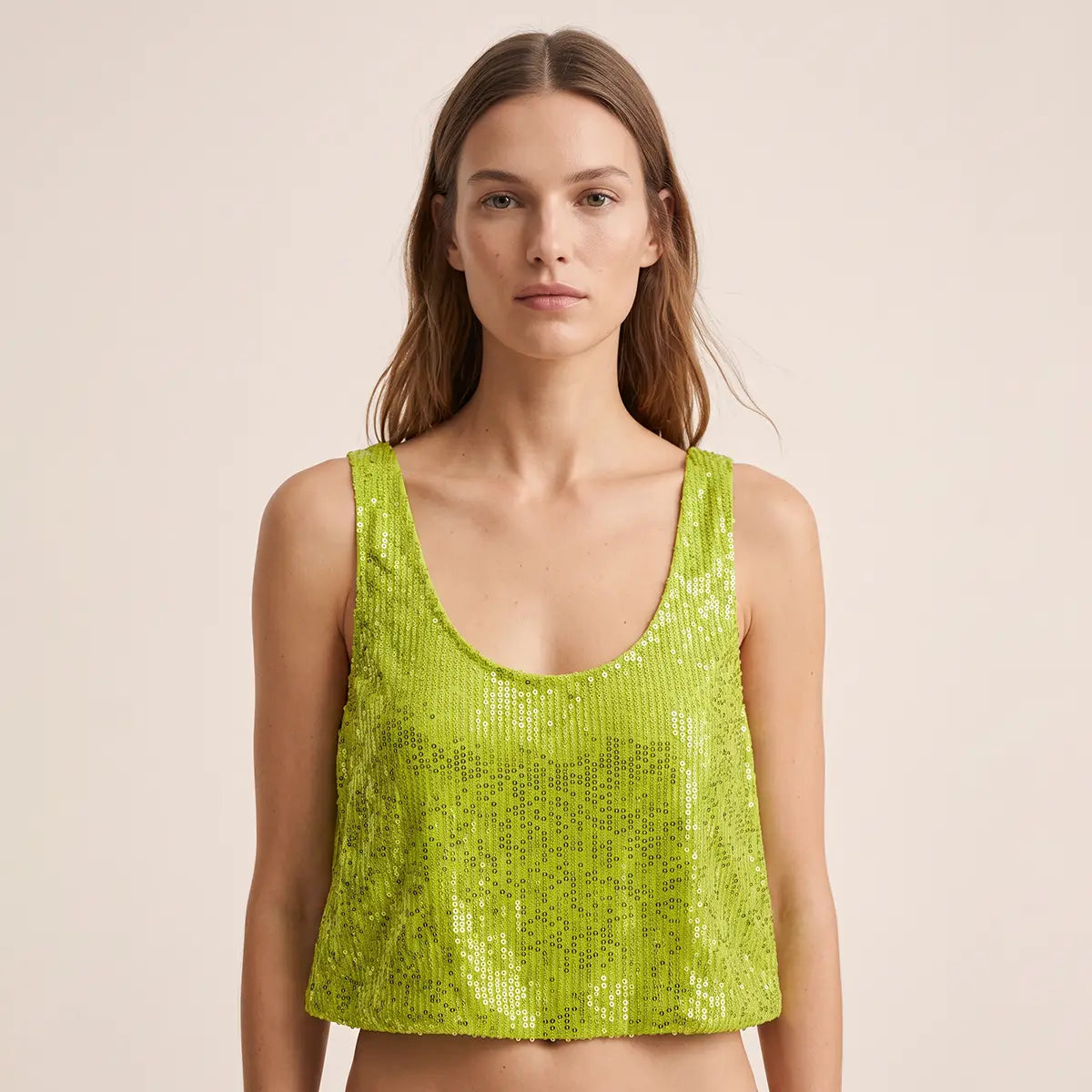 ANDROMEDA, crop top in paillettes verdi con scollo rotondo e spalle larghe, su modella.