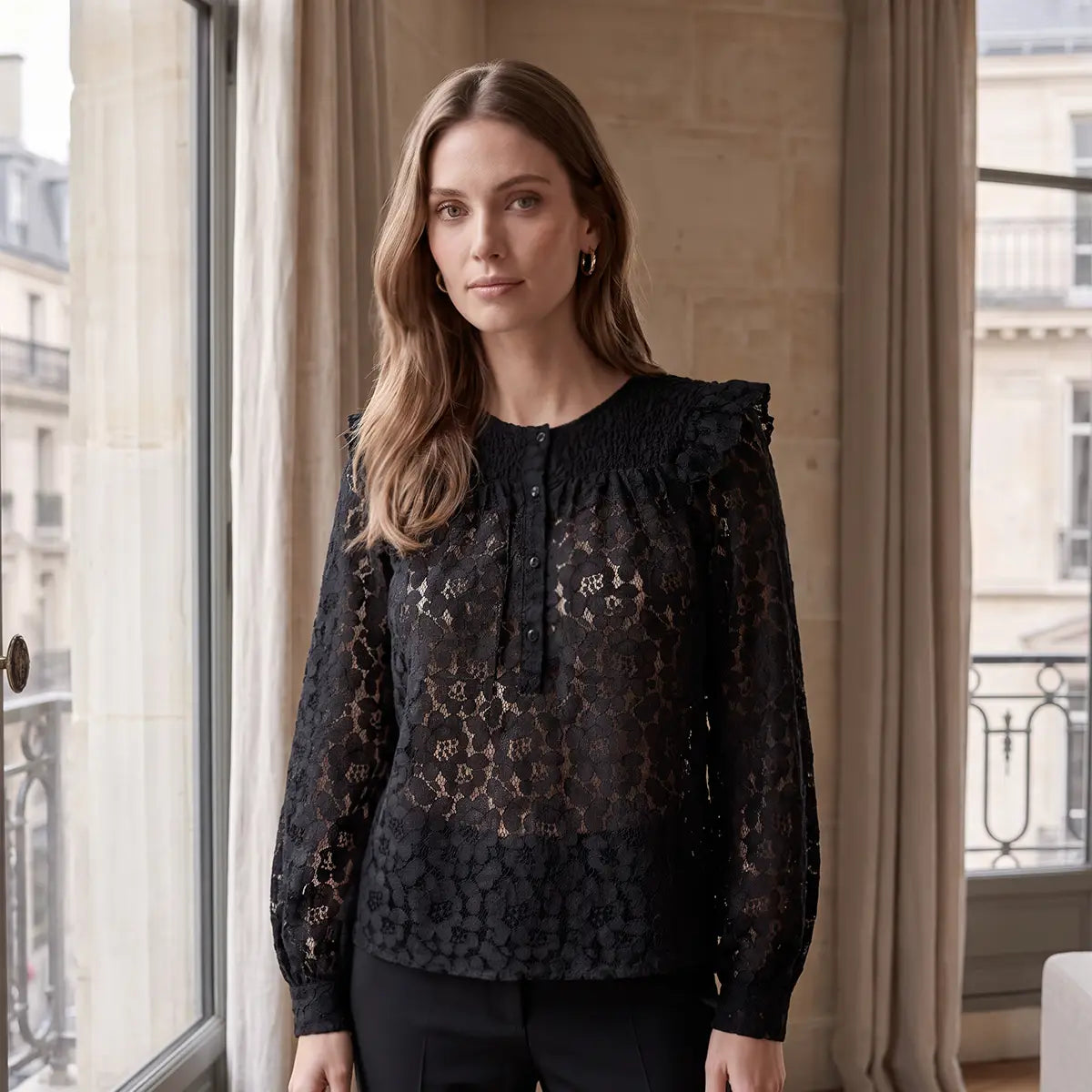 ARYA, camicia in pizzo nera con rouches sulle spalle e maniche a palloncino, su modella.