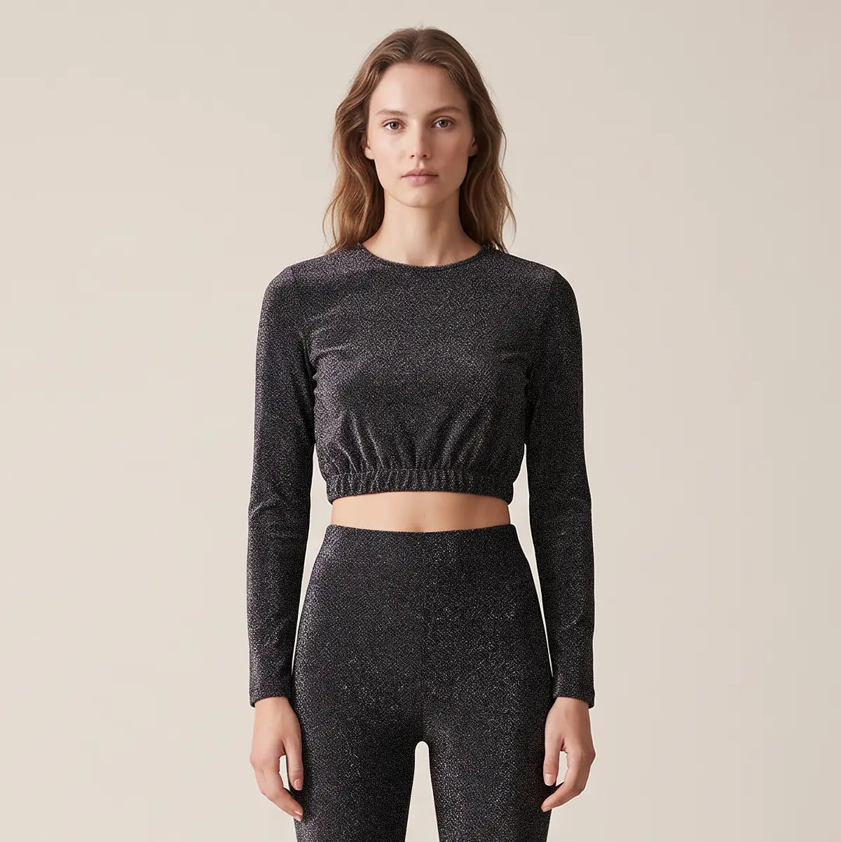 BICE, crop top in lurex antracite con girocollo e maniche lunghe, su modella.