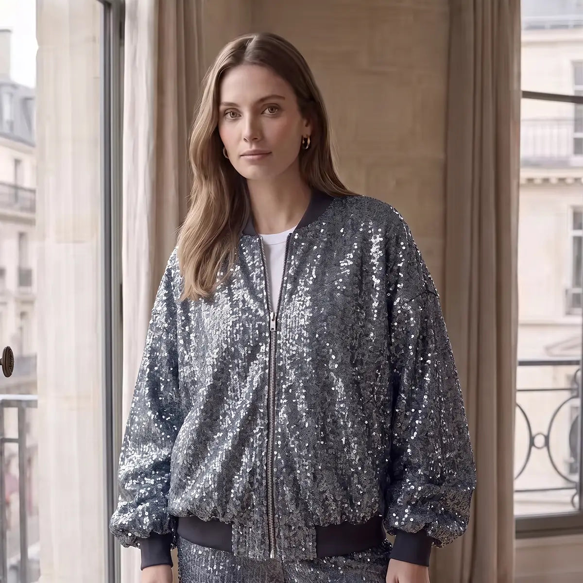 BOMBER, piumino in paillettes azzurre con zip frontale e polsini, su modella.