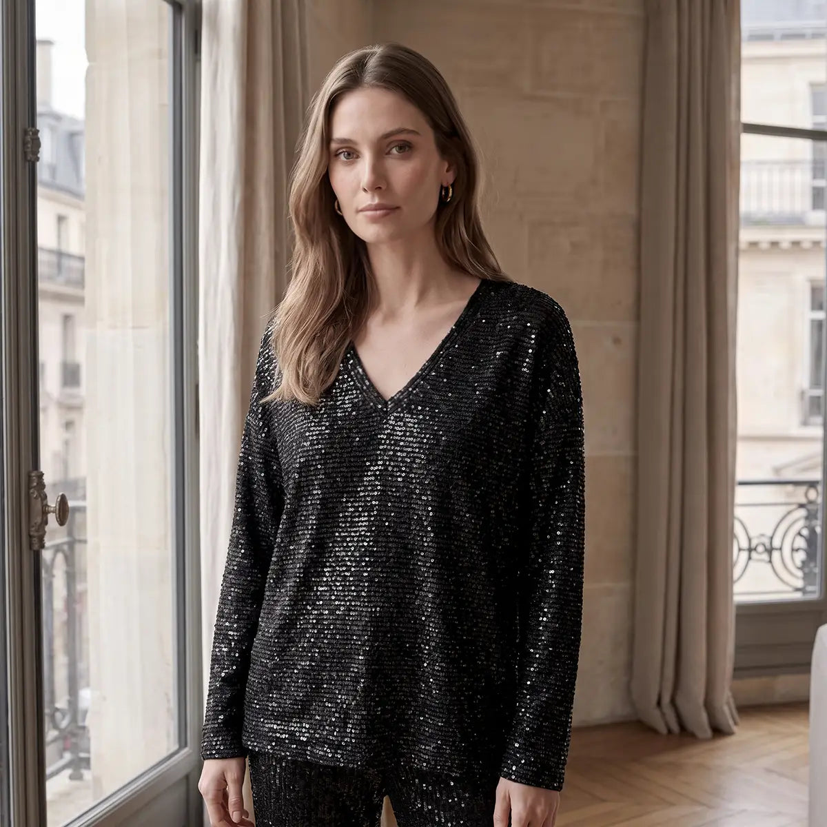 EVA, felpa in paillettes nere con scollo a V e maniche lunghe, su modella.
